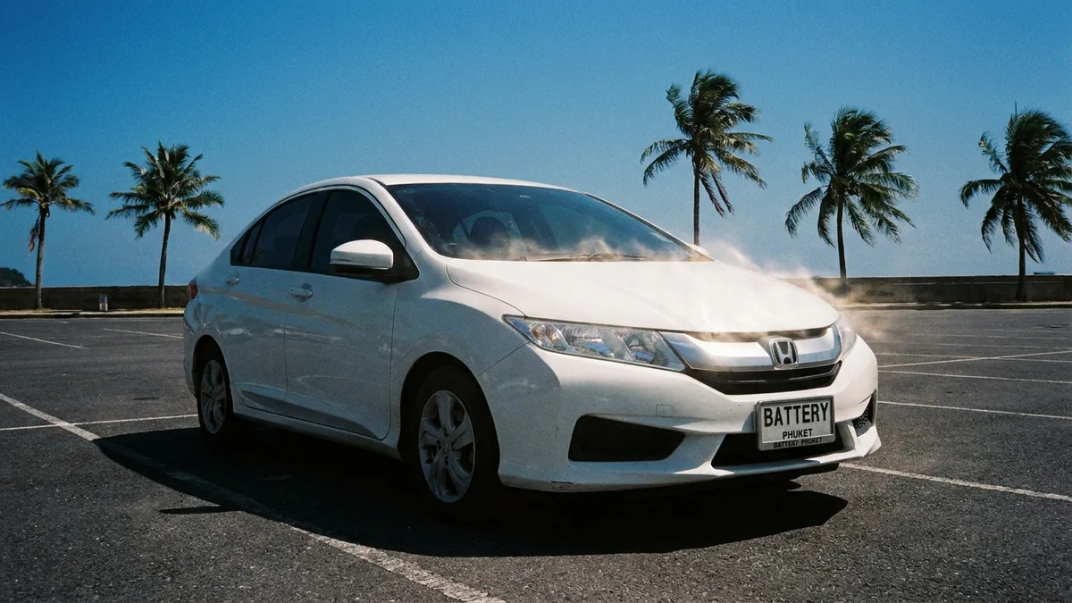 Car battery under a hot Phuket sun showing heat damage and corrosion on terminals
